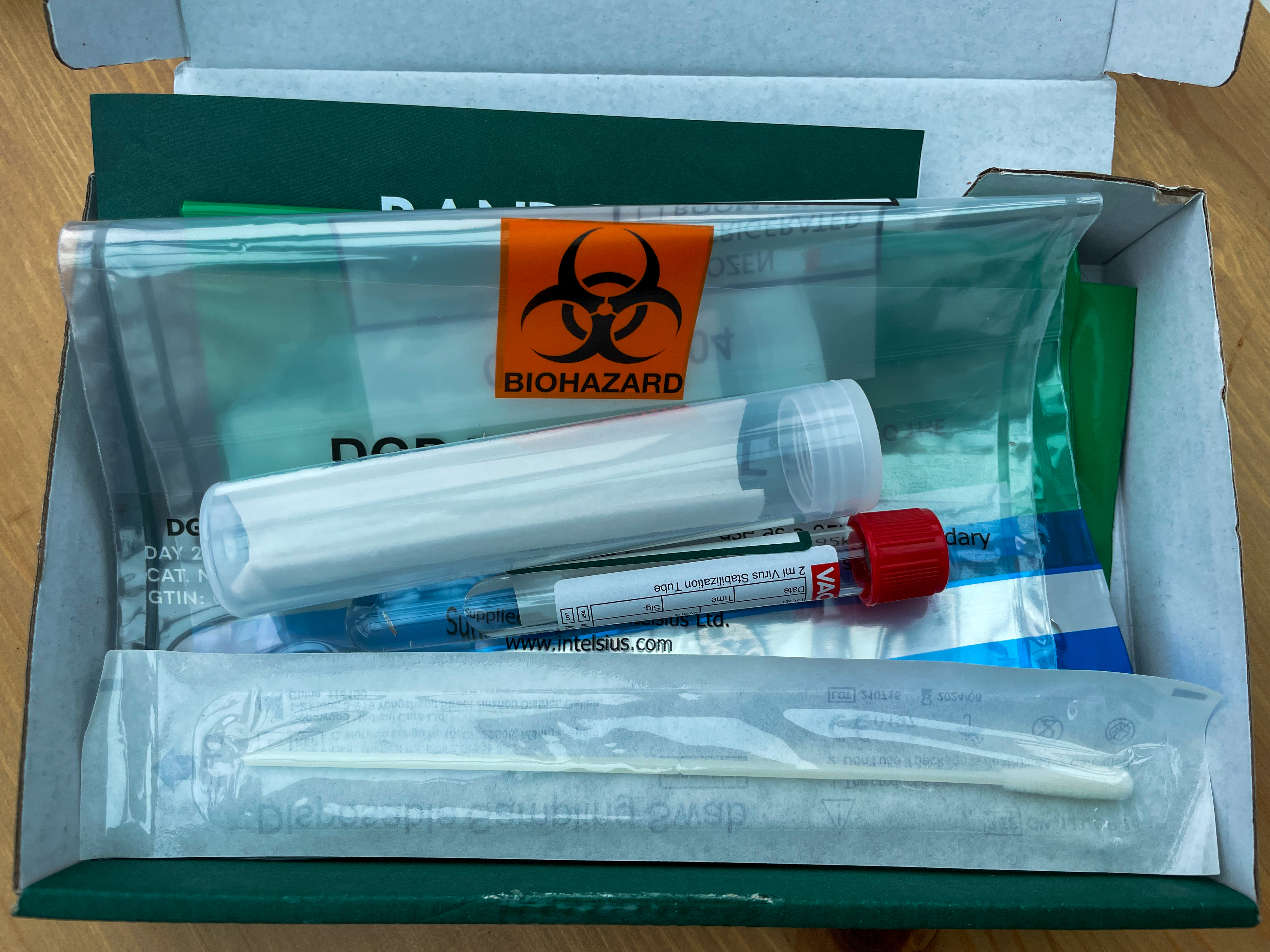 An at-home test kit with its collection components laid out ready to use