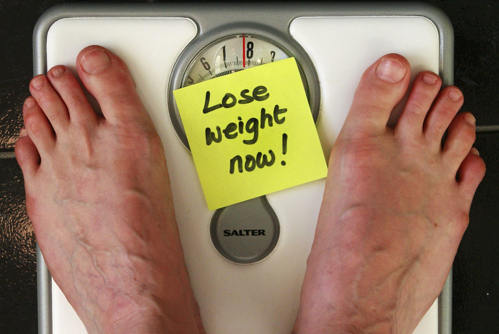A tape measure and note reading lose weight, representing lifestyle factors